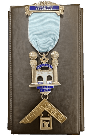 Past Masters Jewel Freemasons in Guildford Surrey. A Past Masters Jewel depicting the bridge over the River Wey at Weybridge between the two columns from the entrance of King Solomon temple with a builders square set below. The top ribbon is adorned with a plate inscribed in latin 'Trigesimus Secundus' or thirty second. The jewel is cast from 18ct gold and enamelled with a light blue ribbon.
